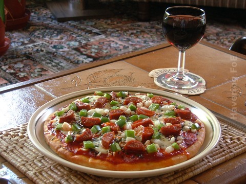 Pizza on a plate and a glass of red wine